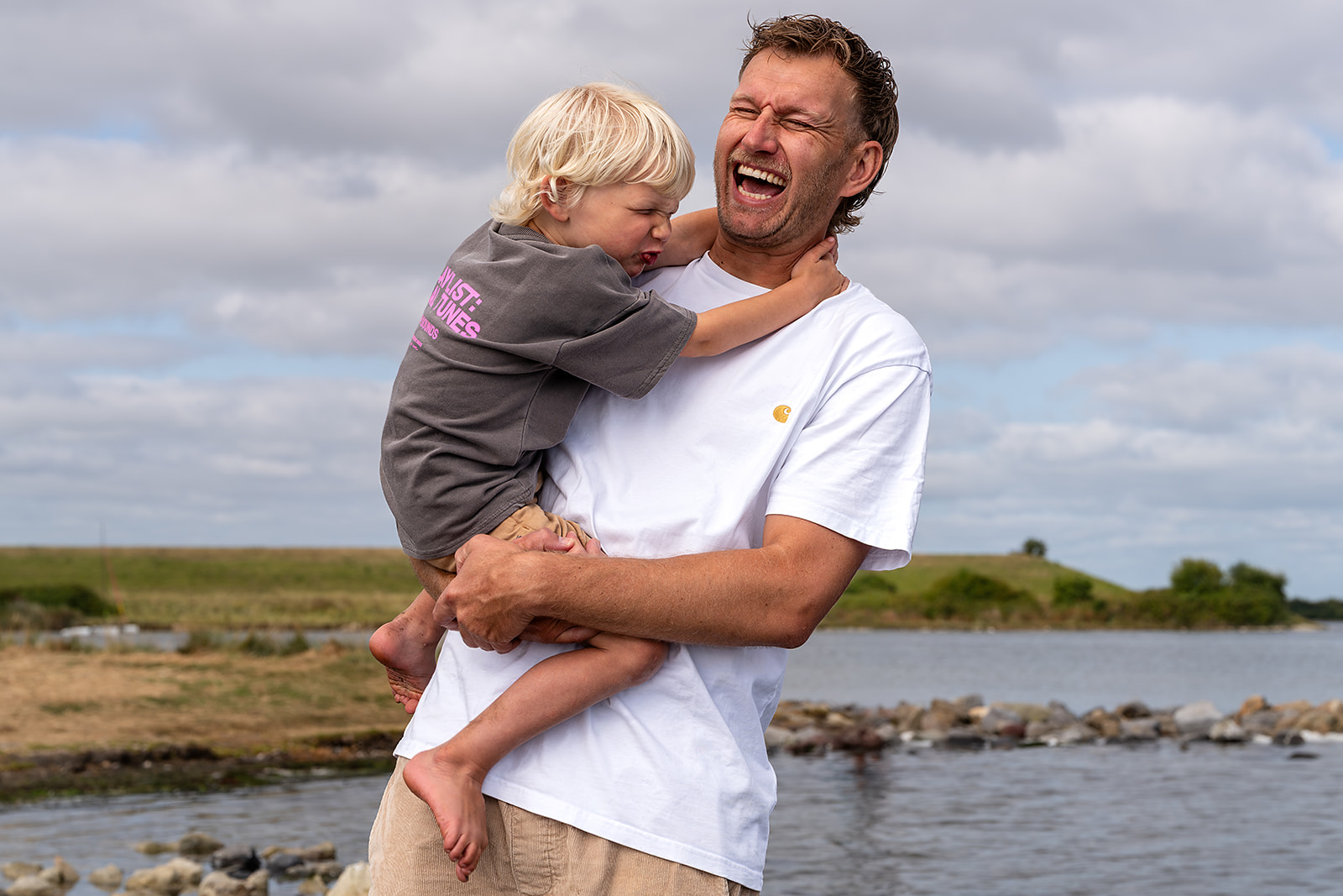 vader en zoon, samen lachen tijdens de familiefotoshoot