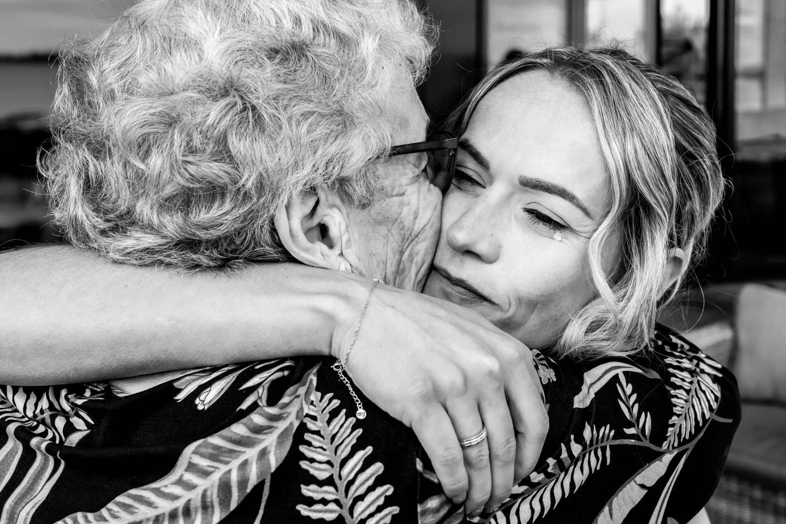 Documentaire trouwfotografie van een emotionele omhelzing tussen oma en de bruid tijdens de receptie