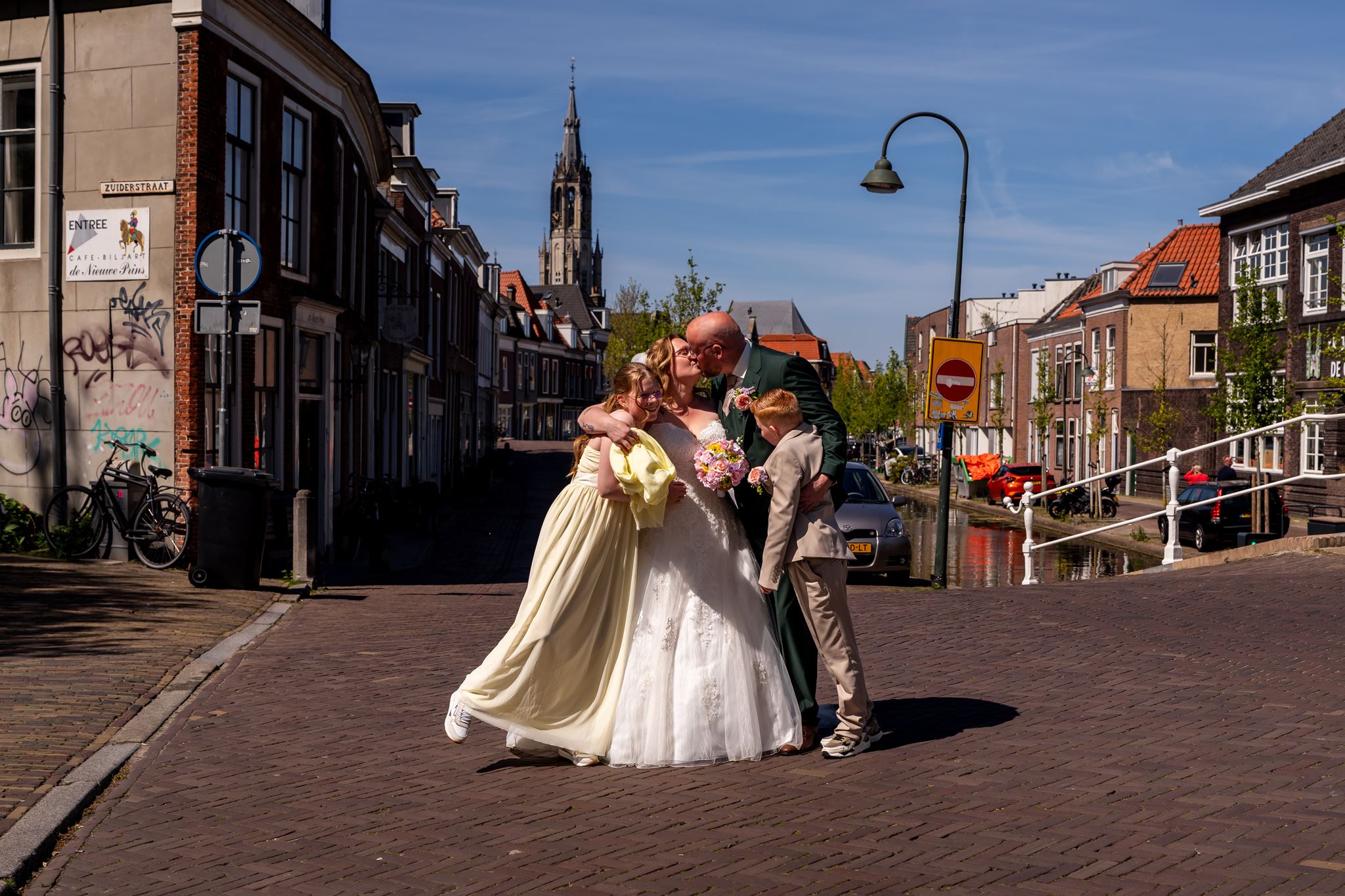 Bruidspaar wandelt met de kinderen door de straten van Delft op hun trouwdag, documentaire trouwfotografie