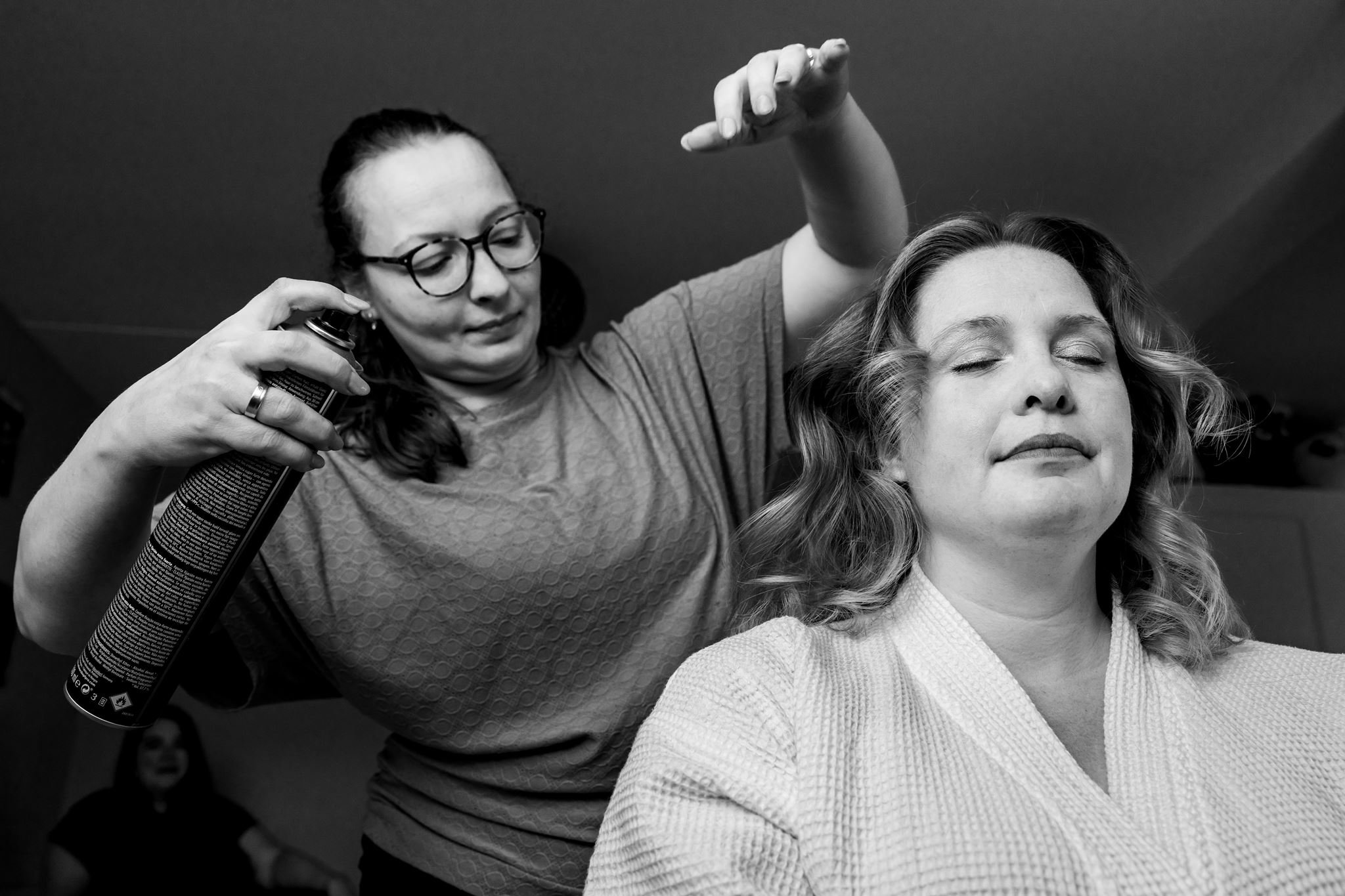 Lachen en ontspanning tijdens de voorbereidingen van de bruid in Rijswijk, documentaire trouwfotografie in zwart-wit