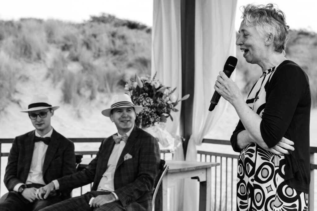 Moeder houdt een speech tijdens de strandceremonie in Renesse, zwart-wit