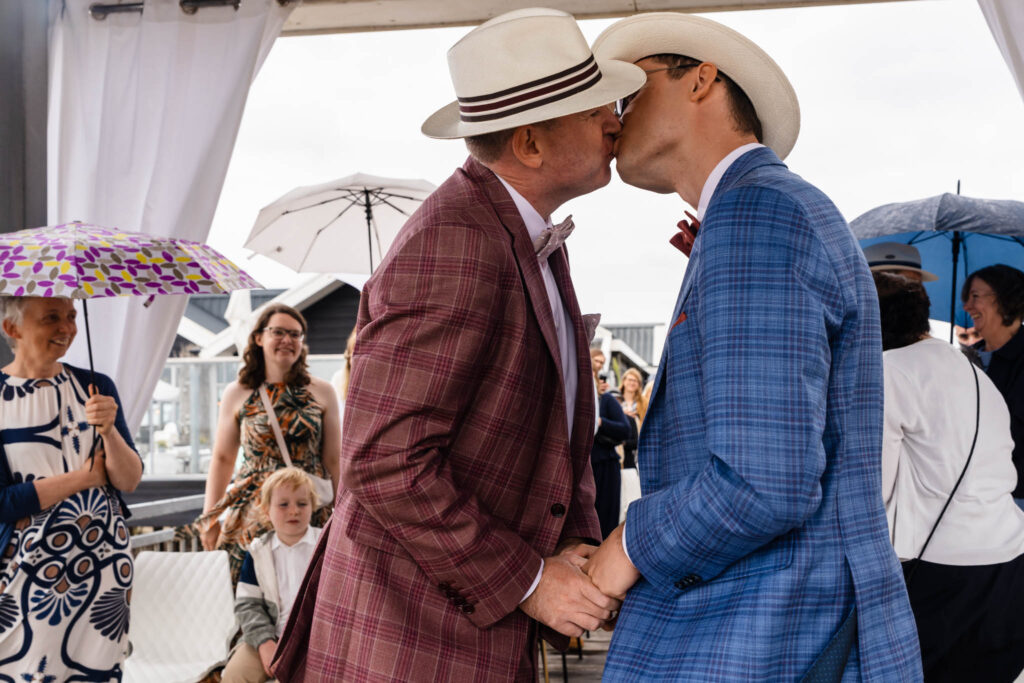 Eerste kus van de bruidegoms na de ceremonie in Renesse