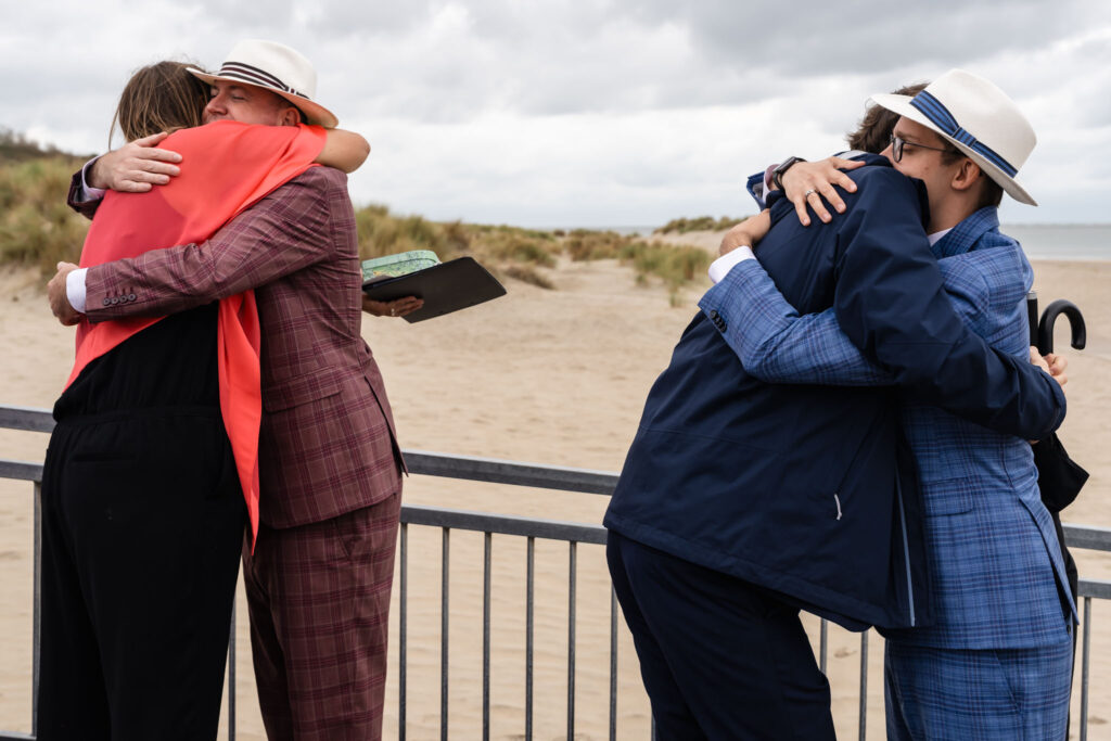 Bruidegoms worden tegelijk omhelsd tijdens de felicitaties in Renesse