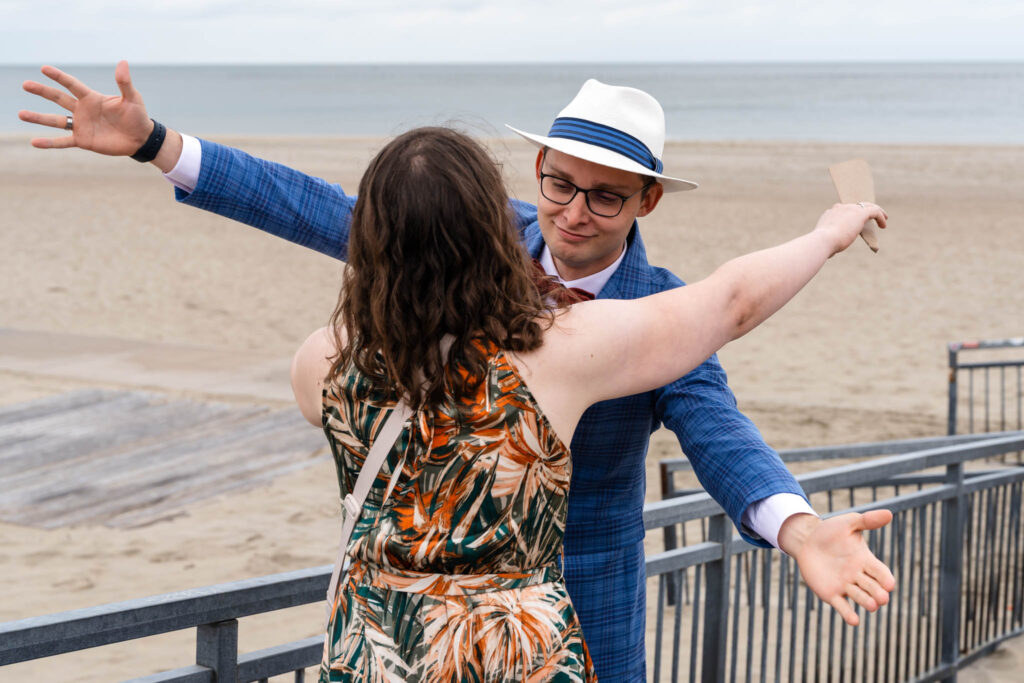 Gast spreidt de armen tijdens de felicitaties aan het strand van Renesse