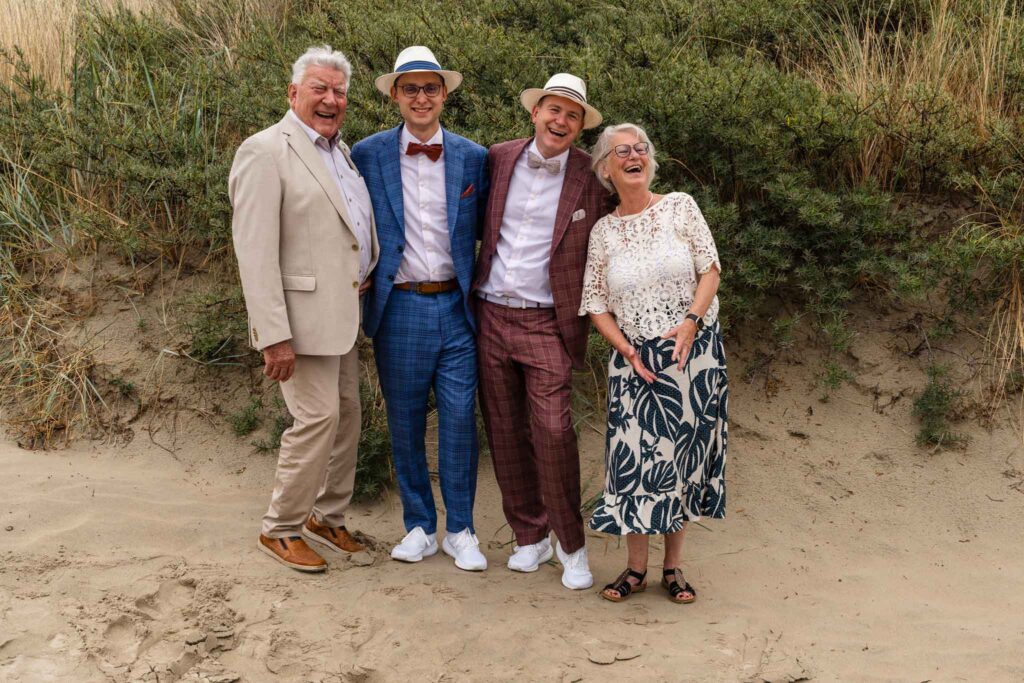 Groepsfoto van de bruidegoms met familie in de duinen van Renesse