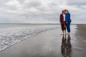Bruidegoms kussen aan de vloedlijn op het strand van Renesse