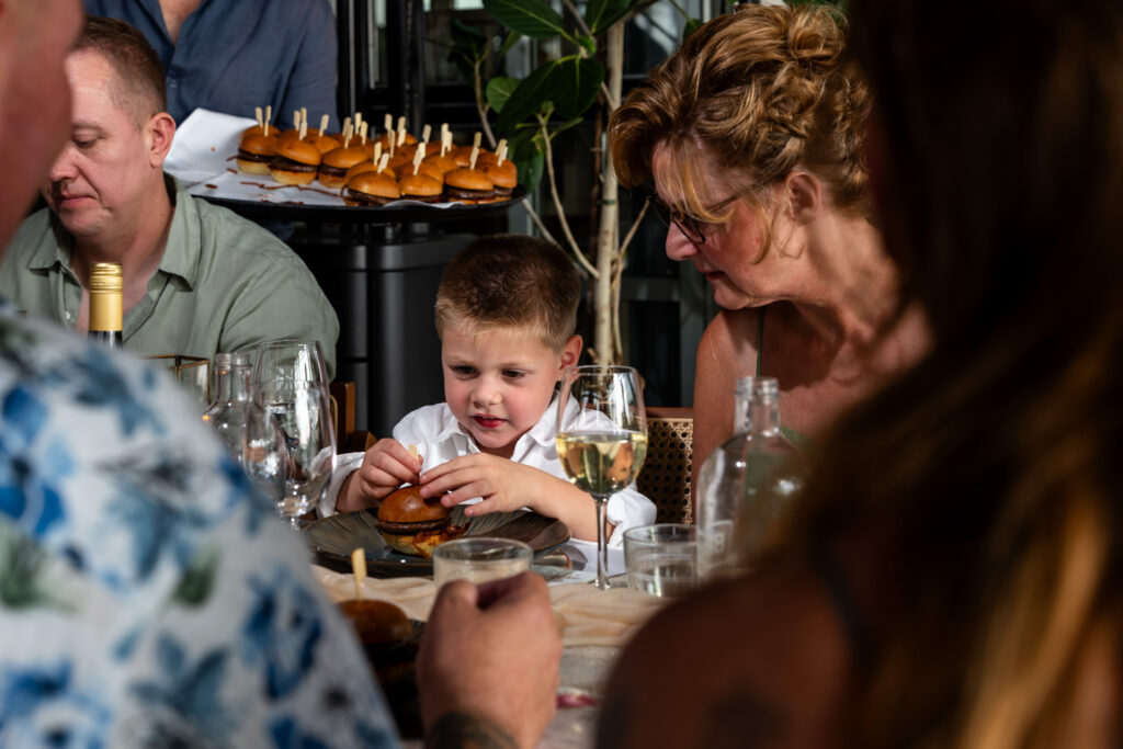 Gasten en een kind aan tafel tijdens het diner in Valkenburg, documentaire trouwfotografie