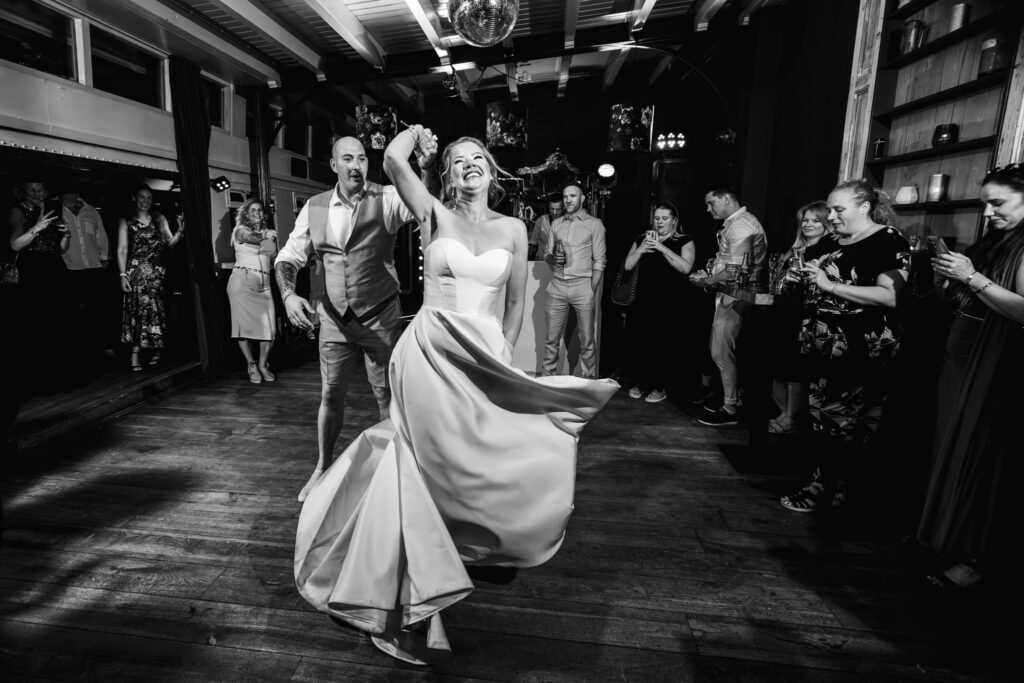 Openingsdans met gasten eromheen, documentaire trouwfotografie in zwart-wit