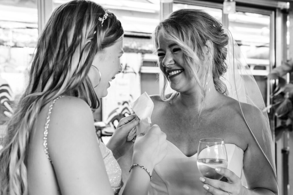 Bruid omhelst een gast na de ceremonie in Valkenburg, documentaire trouwfotografie